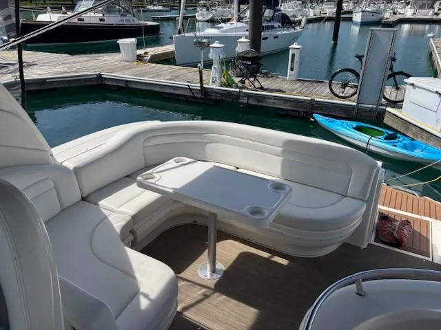 Slide: The Image of 2003 Sea Ray 340 Sundancer boat interior with white seating and table at marina. - 4