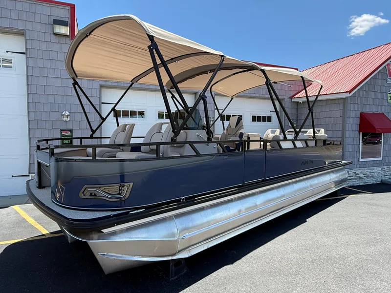 Slide: The Image of 2025 Avalon 2585 Venture 85 Tri Toon boat with center console, parked outdoors. - 1