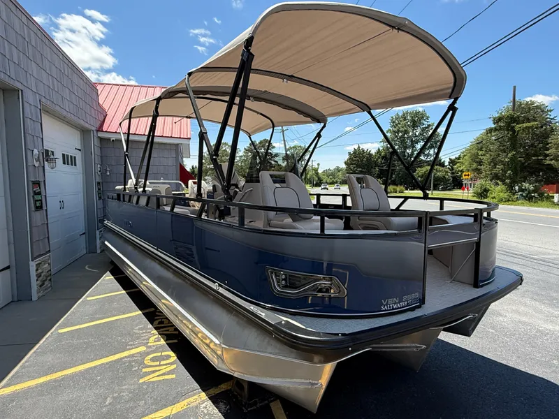 Slide: The Image of 2025 Avalon 2585 Venture 85 Tri Toon boat with center console, parked outdoors. - 10