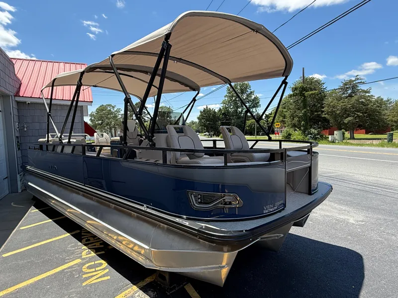 Slide: The Image of 2025 Avalon 2585 Venture 85 Tri Toon boat with center console, parked outdoors. - 7