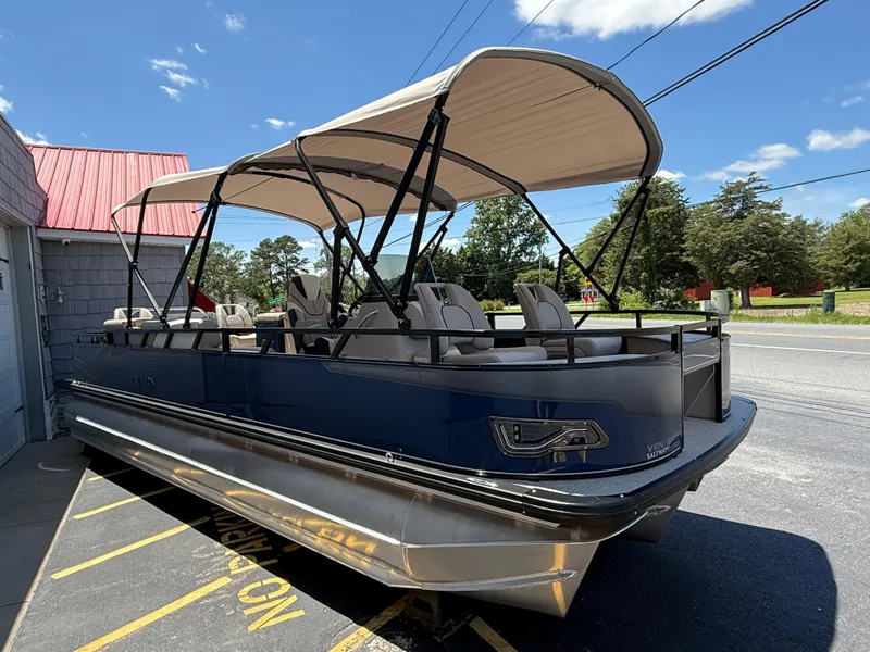 Slide: The Image of 2025 Avalon 2585 Venture 85 Tri Toon boat with canopy, parked outdoors. - 8
