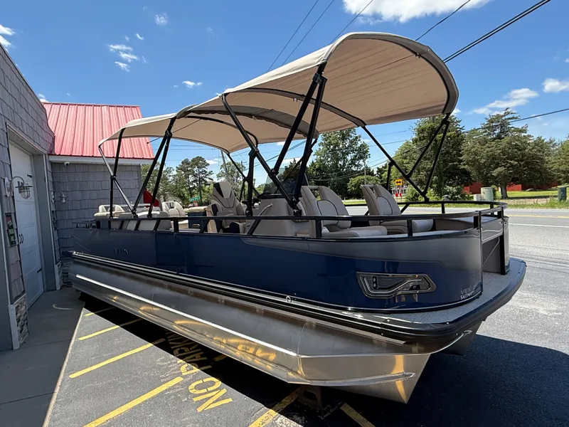 Slide: The Image of 2025 Avalon 2585 Venture 85 Tri Toon boat with center console, parked outdoors. - 9