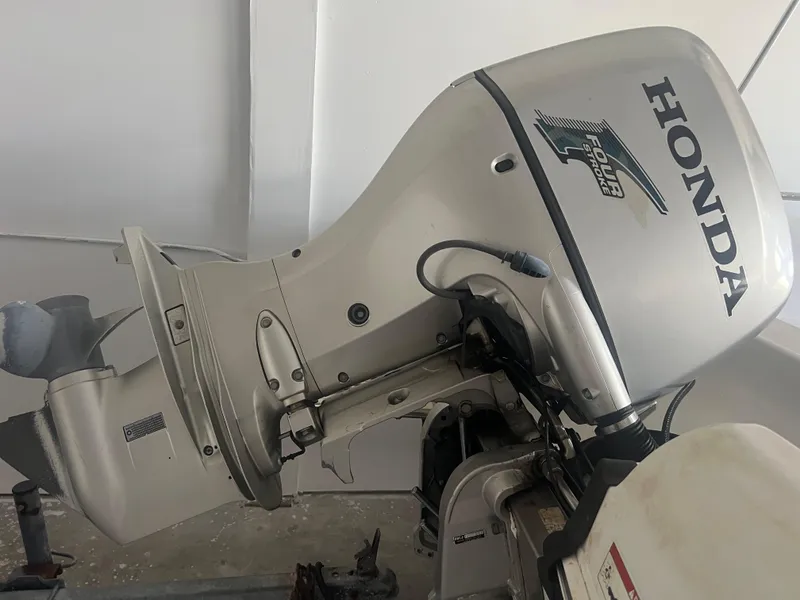 Slide: The Image of 2009 Triumph 190 Bay with Honda outboard motor in a garage setting. - 6