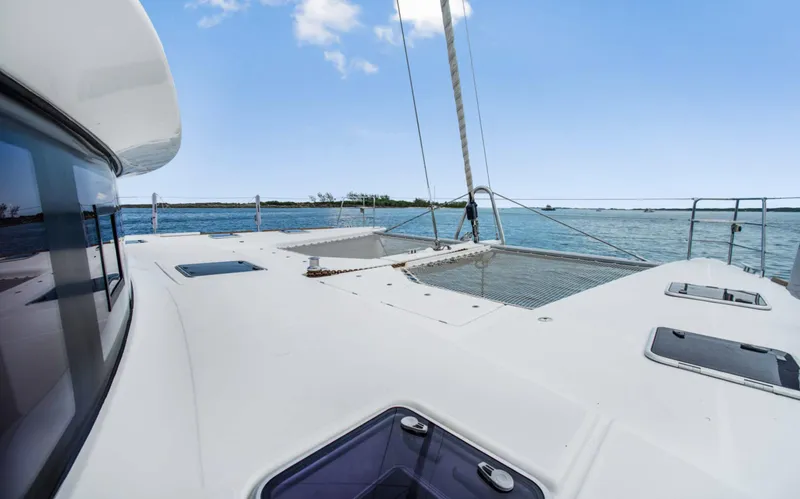Slide: The Image of Lagoon 620 catamaran deck view, sailing on clear blue waters, 2020 model. - 10