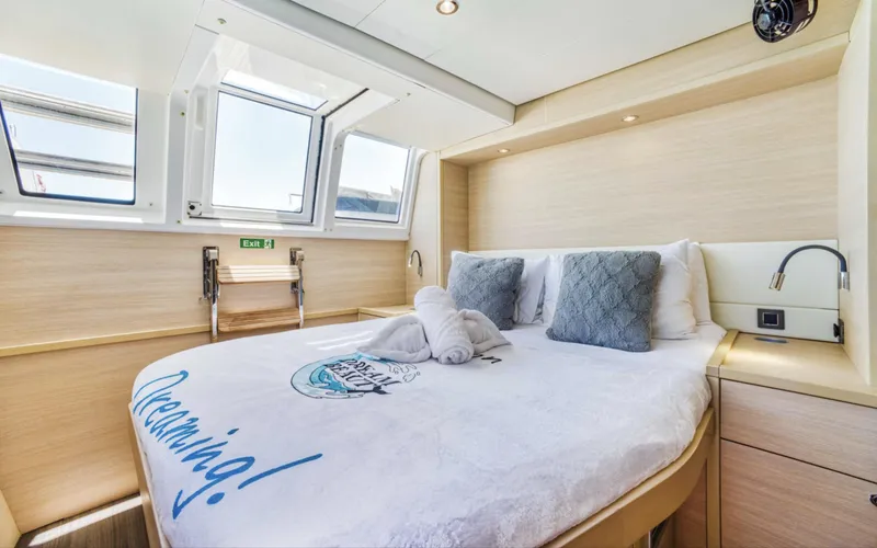 Slide: The Image of Luxurious cabin interior of 2020 Lagoon 620 yacht with cozy bed and natural light. - 16