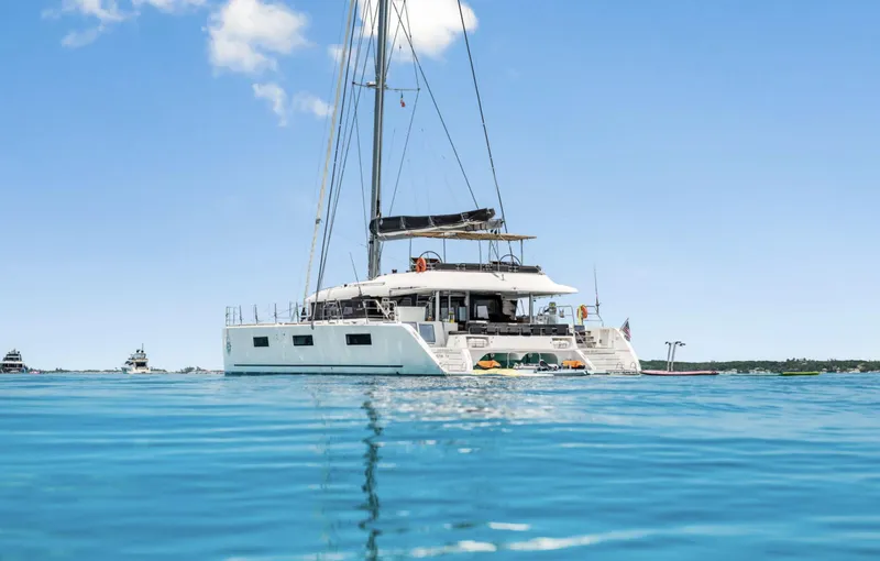Slide: The Image of 2020 Lagoon 620 catamaran sailing on clear blue water under a sunny sky. - 2