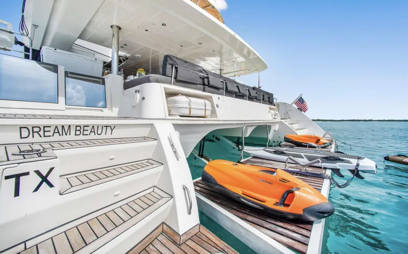 Slide: The Image of Luxury Lagoon 620 yacht with jet skis, docked on clear blue water, 2020 model. - 3