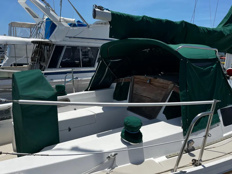 Slide: The Image of 1987 Catalina 34 sailboat with green canvas cover, docked at marina. - 11