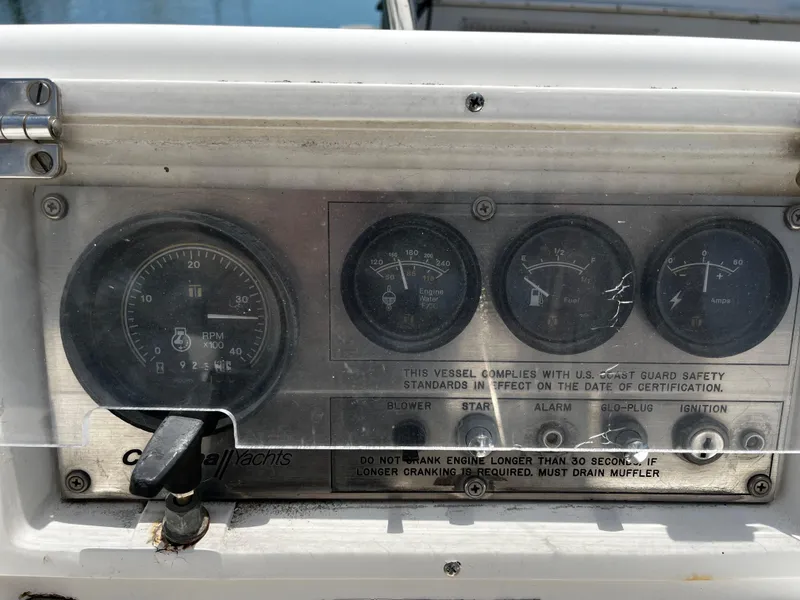 Slide: The Image of Instrument panel of a 1987 Catalina 34 sailboat with gauges and safety instructions. - 12