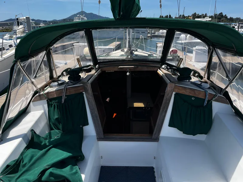 Slide: The Image of 1987 Catalina 34 sailboat cockpit with green canopy, docked at marina. - 15