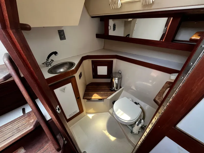 Slide: The Image of 1987 Catalina 34 yacht bathroom with sink, toilet, and wooden accents. - 17