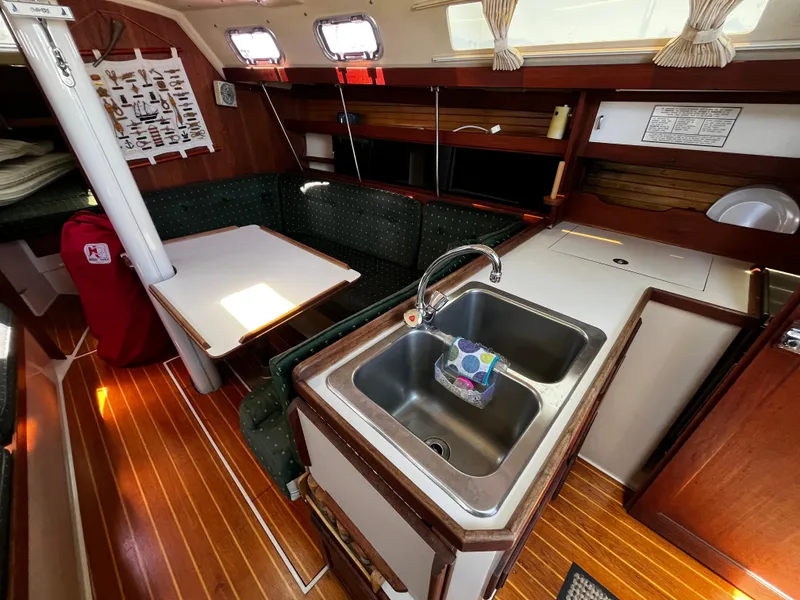 Slide: The Image of Interior of a 1987 Catalina 34 sailboat with a cozy dining area and kitchen sink. - 22