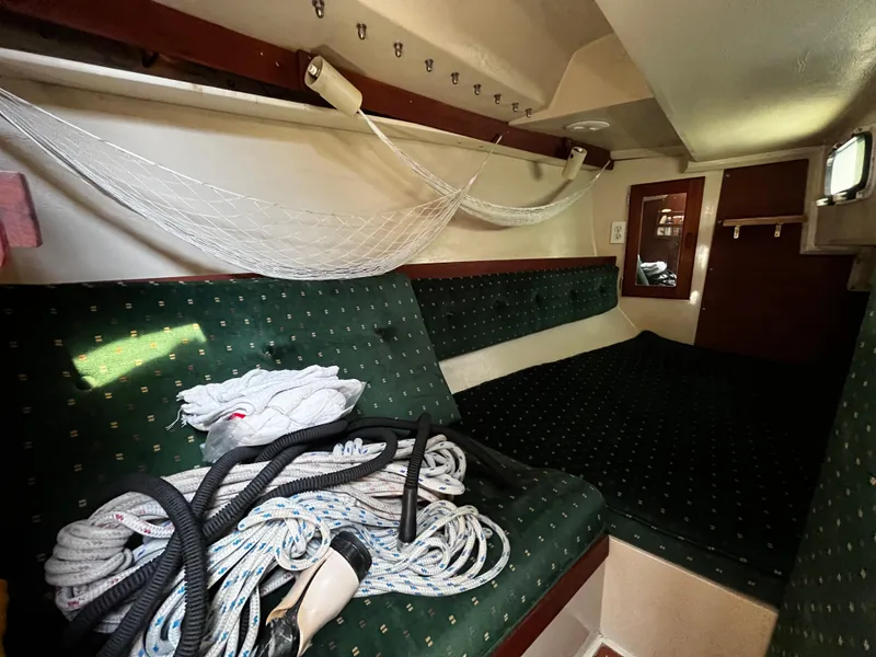 Slide: The Image of Interior of 1987 Catalina 34 sailboat with green upholstery and coiled ropes. - 24