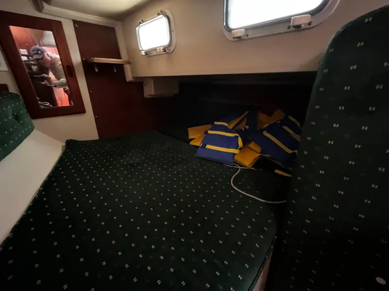 Slide: The Image of Cabin interior of 1987 Catalina 34 sailboat with life jackets on bed. - 25