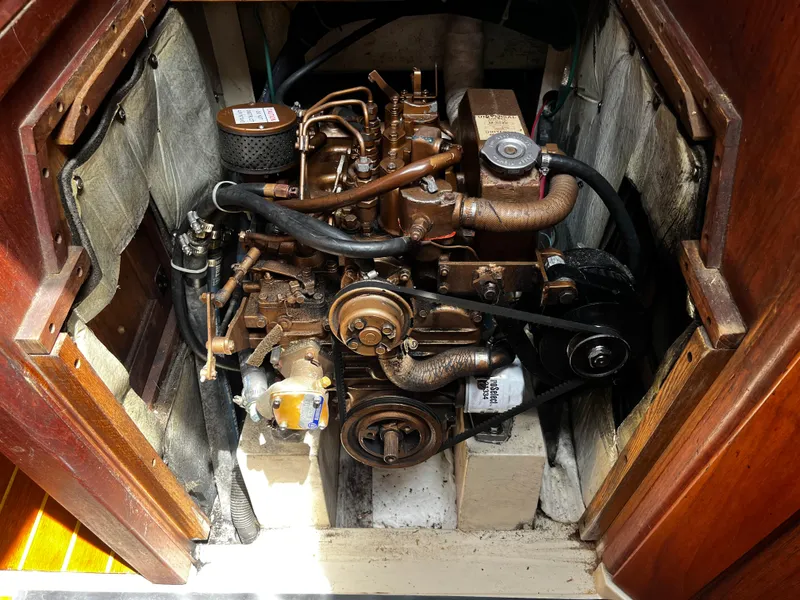 Slide: The Image of Engine compartment of a 1987 Catalina 34 sailboat, showcasing mechanical components and hoses. - 28
