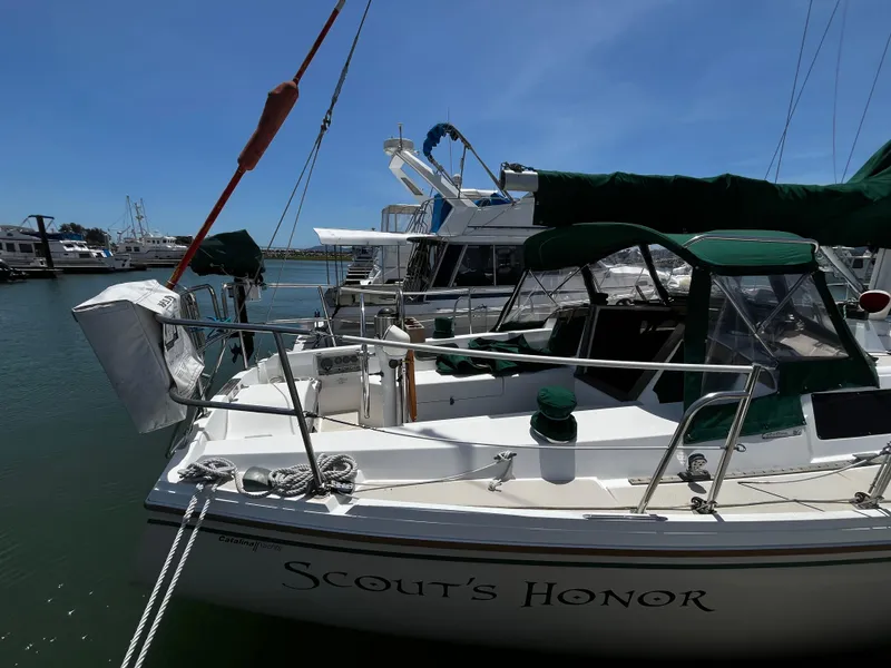Slide: The Image of 1987 Catalina 34 sailboat "Scout's Honor" docked in a marina under clear blue skies. - 3