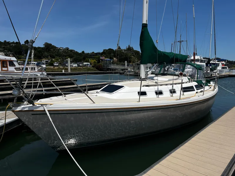 Slide: The Image of 1987 Catalina 34 sailboat docked at marina under clear blue sky. - 5