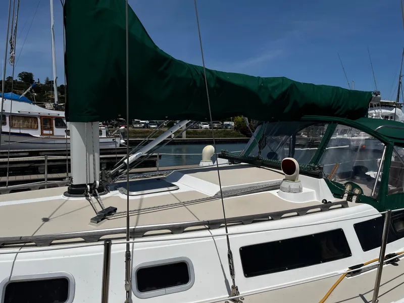 Slide: The Image of 1987 Catalina 34 sailboat with green sail cover docked at marina. - 6
