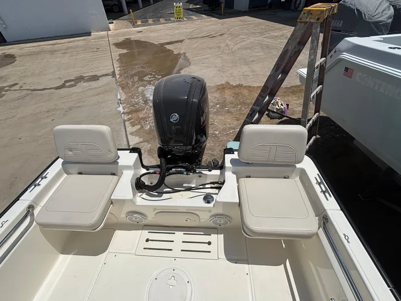 Slide: The Image of 2024 Boston Whaler 170 Montauk boat interior with seating and outboard motor. - 14