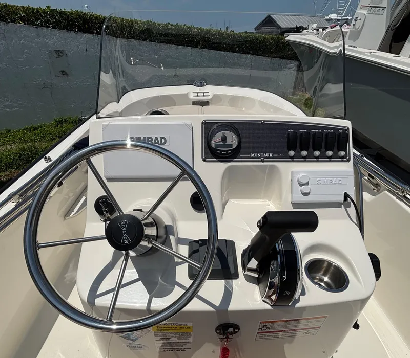Slide: The Image of 2024 Boston Whaler 170 Montauk boat console with steering wheel and controls. - 7