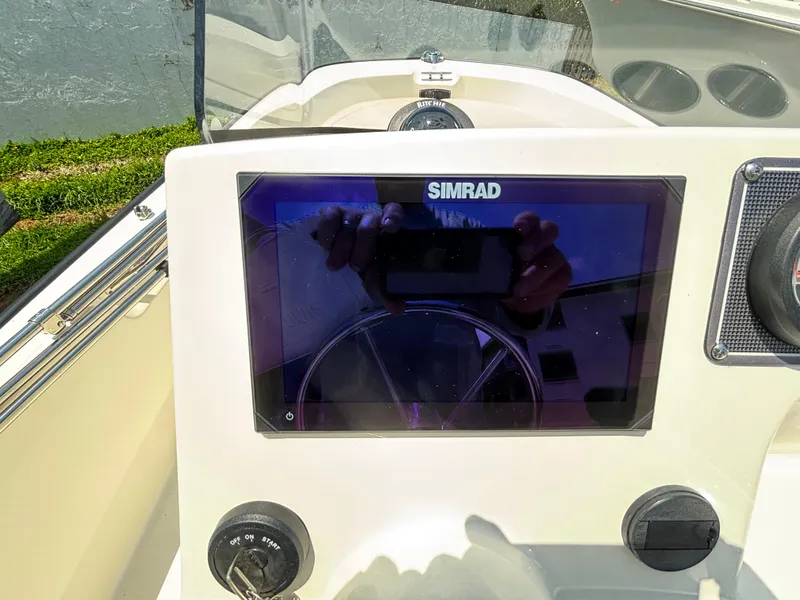 Slide: The Image of 2024 Boston Whaler 170 Montauk dashboard with Simrad display and steering wheel. - 8