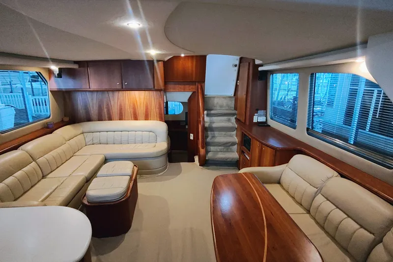 Slide: The Image of Luxurious interior of a 2002 Silverton 43 Motor Yacht with plush seating and wood finishes. - 17