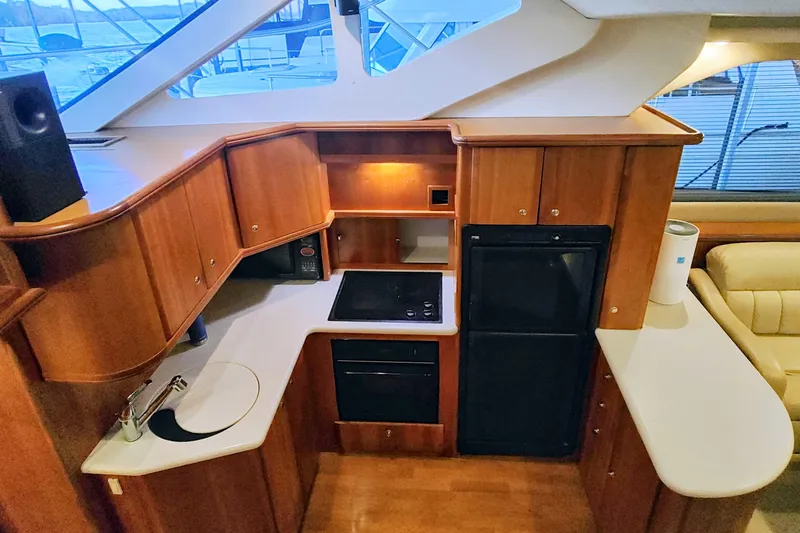 Slide: The Image of 2002 Silverton 43 Motor Yacht kitchen with wood cabinetry and modern appliances. - 21
