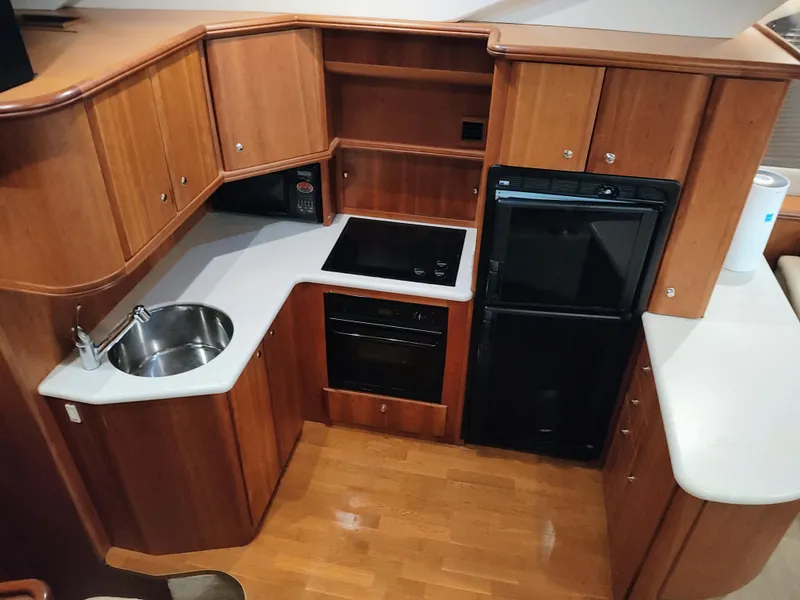 Slide: The Image of 2002 Silverton 43 Motor Yacht kitchen with wood cabinetry and modern appliances. - 22