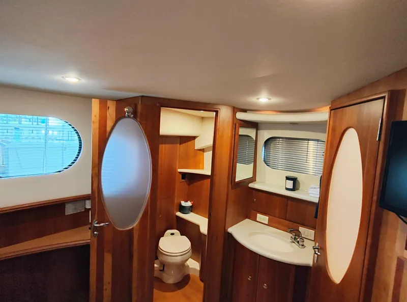 Slide: The Image of Interior of 2002 Silverton 43 Motor Yacht bathroom with wood accents and modern fixtures. - 28