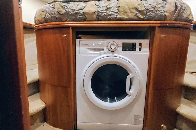 Slide: The Image of Washing machine in 2002 Silverton 43 Motor Yacht interior, surrounded by wooden cabinetry. - 32