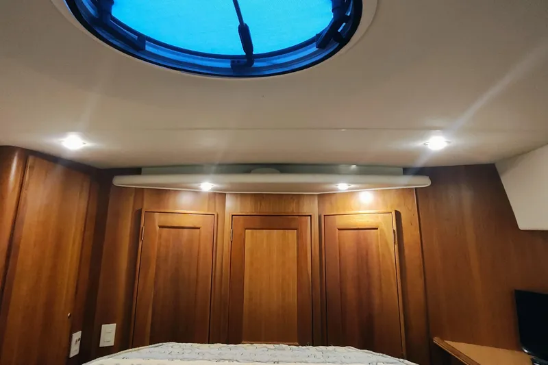 Slide: The Image of Interior cabin of 2002 Silverton 43 Motor Yacht with wooden paneling and ceiling hatch. - 34