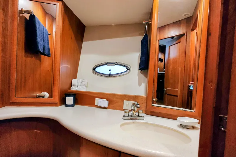 Slide: The Image of Luxurious bathroom interior of 2002 Silverton 43 Motor Yacht with wood accents and oval window. - 36