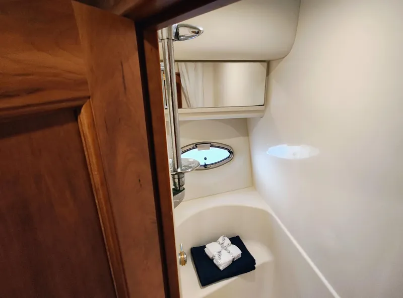 Slide: The Image of Luxurious bathroom interior of 2002 Silverton 43 Motor Yacht with wooden door and porthole window. - 38
