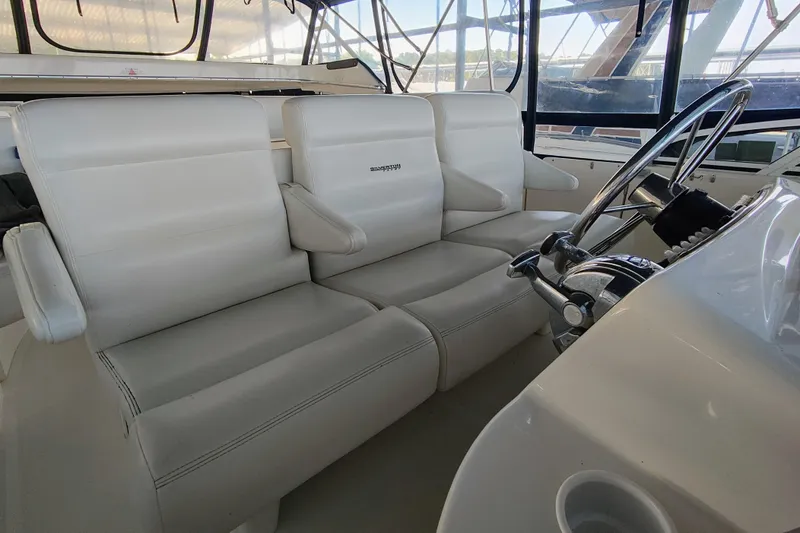 Slide: The Image of Interior of 2002 Silverton 43 Motor Yacht with white leather seating and steering wheel. - 9