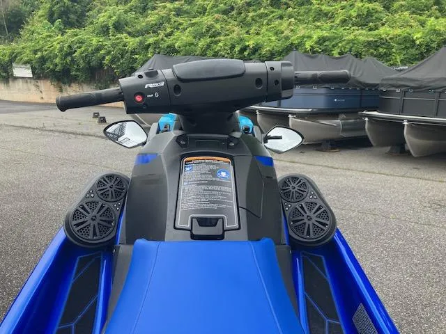 Slide: The Image of 2023 Yamaha WaveRunner EX Limited, blue jet ski, handlebars, and speakers, parked outdoors. - 5