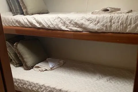 Slide: The Image of Bunk beds in 2002 Viking 55 Convertible yacht cabin, with neatly arranged pillows and linens. - 10