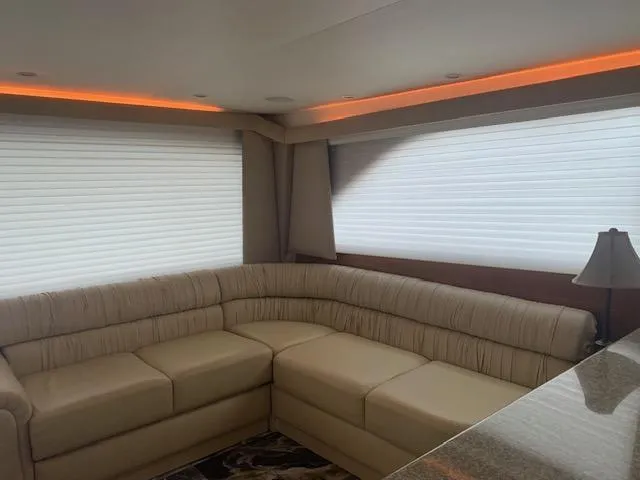 Slide: The Image of Luxurious interior of a 2002 Viking 55 Convertible yacht with beige sectional sofa. - 15