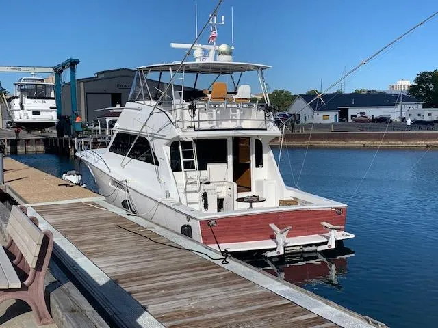 Slide: The Image of 2002 Viking 55 Convertible yacht docked at a marina, clear blue sky. - 2