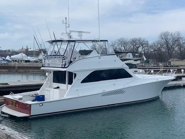 Slide: The Image of 2002 Viking 55 Convertible yacht docked in a marina, featuring a sleek white design. - 25