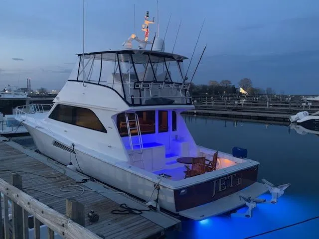Slide: The Image of 2002 Viking 55 Convertible yacht docked at marina, illuminated with blue lights. - 26