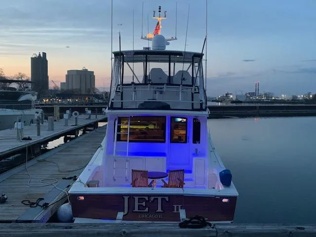 Slide: The Image of 2002 Viking 55 Convertible yacht docked at sunset with blue interior lighting. - 27