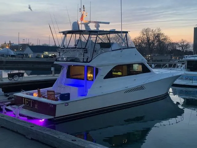 Slide: The Image of 2002 Viking 55 Convertible yacht docked at sunset with blue interior lights. - 28