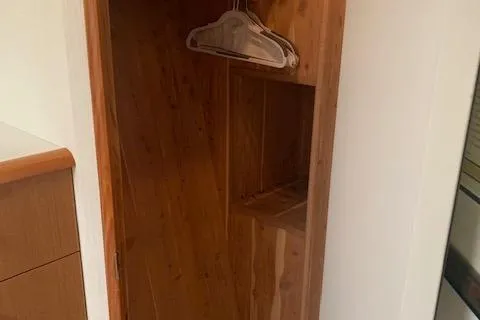 Slide: The Image of Wooden closet interior with hangers in a 2002 Viking 55 Convertible yacht. - 35