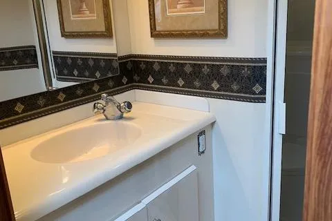 Slide: The Image of Bathroom interior of 2002 Viking 55 Convertible yacht with sink and decorative mirror. - 36