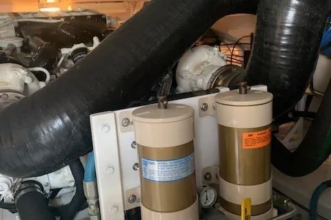 Slide: The Image of Engine components of a 2002 Viking 55 Convertible yacht, featuring hoses and filters. - 42
