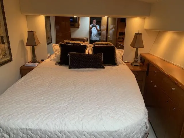 Slide: The Image of Luxurious bedroom interior of 2002 Viking 55 Convertible yacht with elegant bedding and lamps. - 6