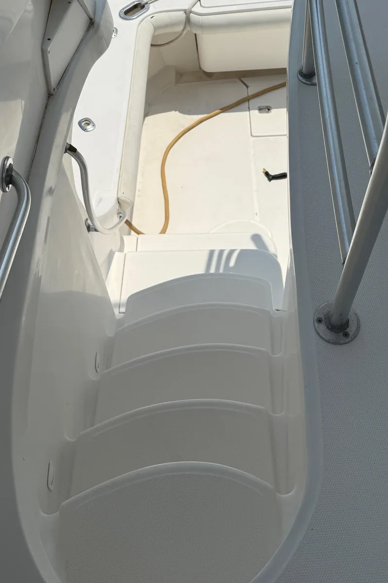 Slide: The Image of 2004 Luhrs 36 Convertible boat stairs and deck area with railing. - 11