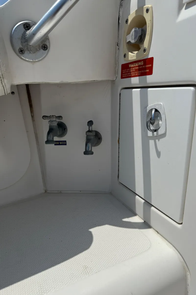 Slide: The Image of 2004 Luhrs 36 Convertible boat deck with control valves and storage compartment. - 12