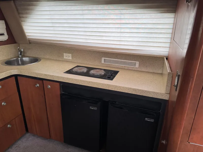 Slide: The Image of 2004 Luhrs 36 Convertible yacht kitchen with stove, sink, and dual refrigerators. - 17