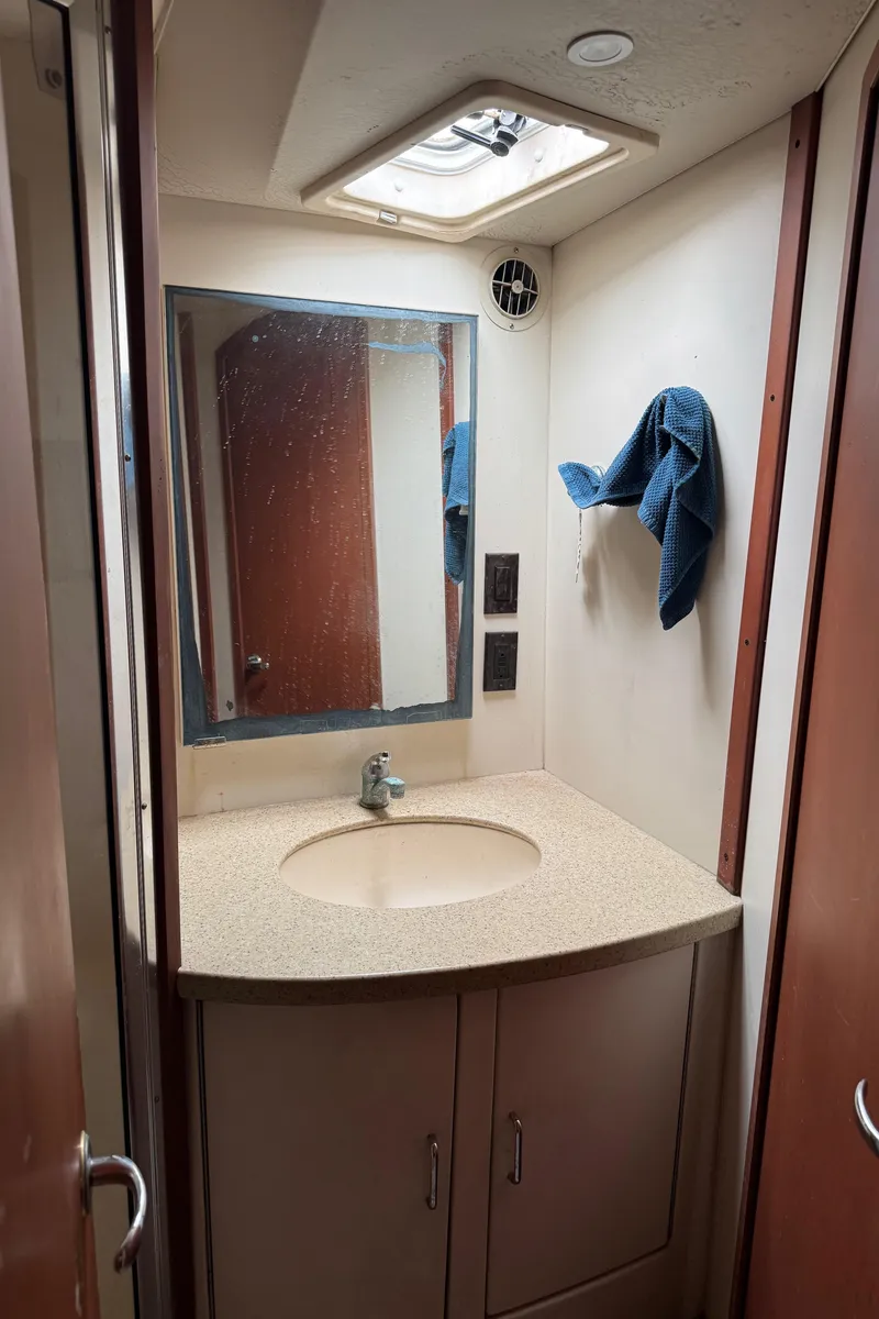 Slide: The Image of 2004 Luhrs 36 Convertible bathroom with sink, mirror, and towel. - 19